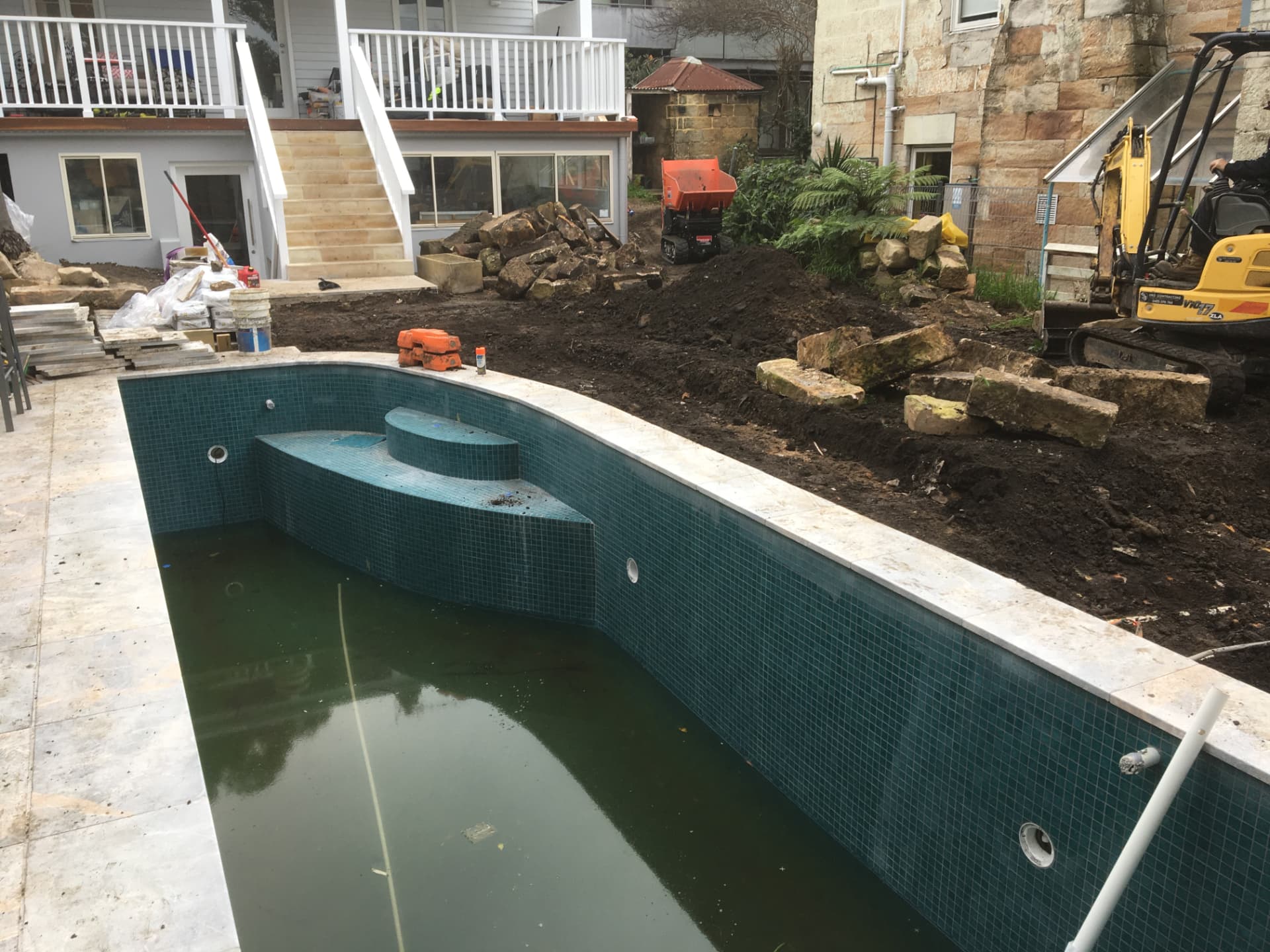 Before - the old pool shell and backyard stripped back for the renovation
