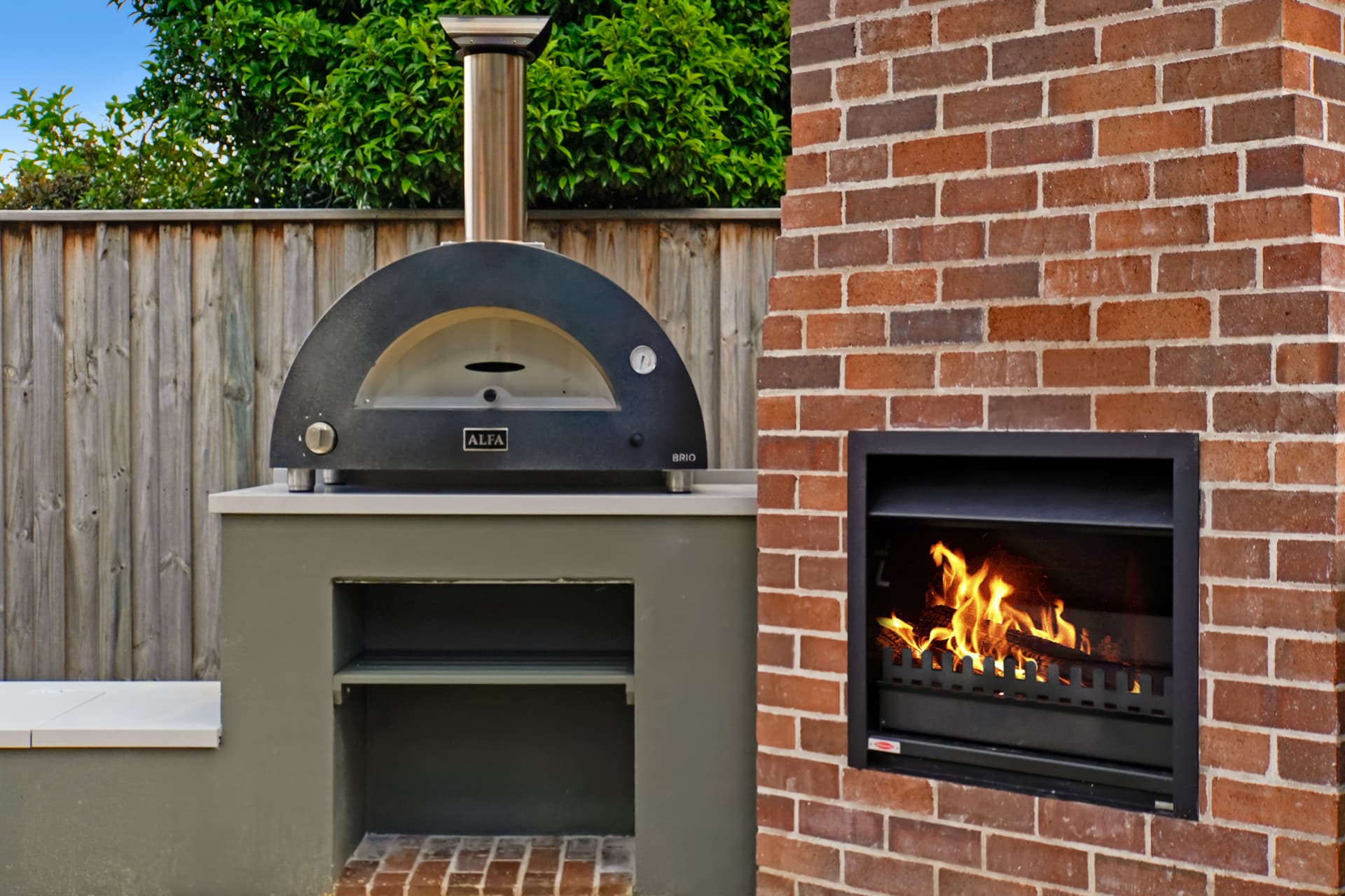 Pizza oven and fireplace fire burning in the Haberfield outdoor entertaining area