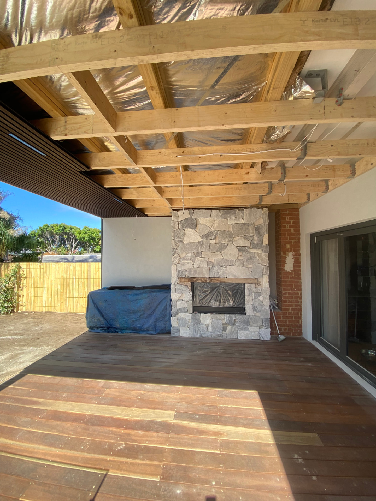 During construction - timber roof framing, hardwood decking and stone fireplace taking shape in the Freshwater outdoor room