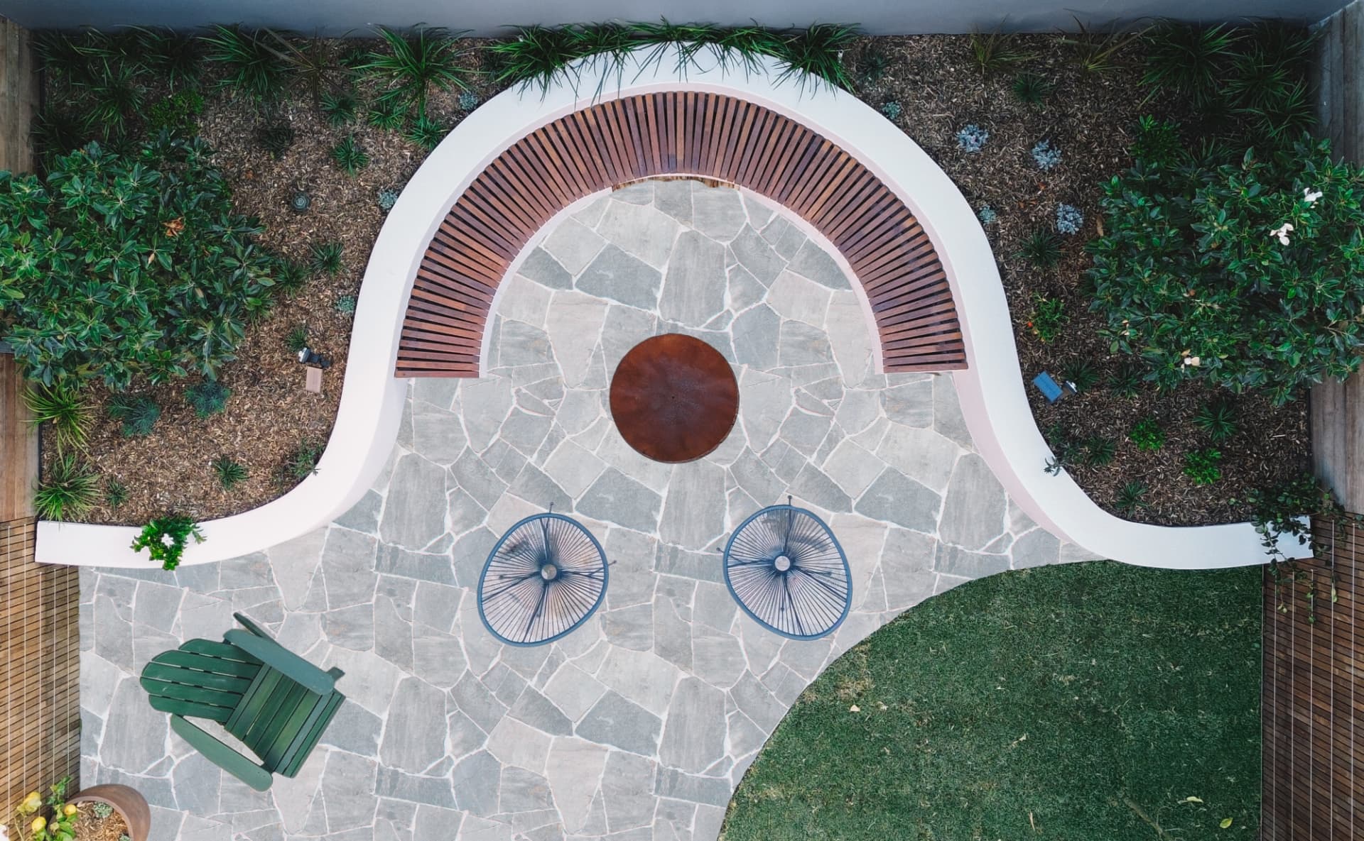 Drone view over the Wareemba backyard showing the curved bench, fire pit and crazy stone paving