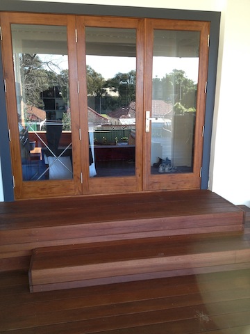 Timber doors opening onto the finished hardwood deck and steps at Kingsford