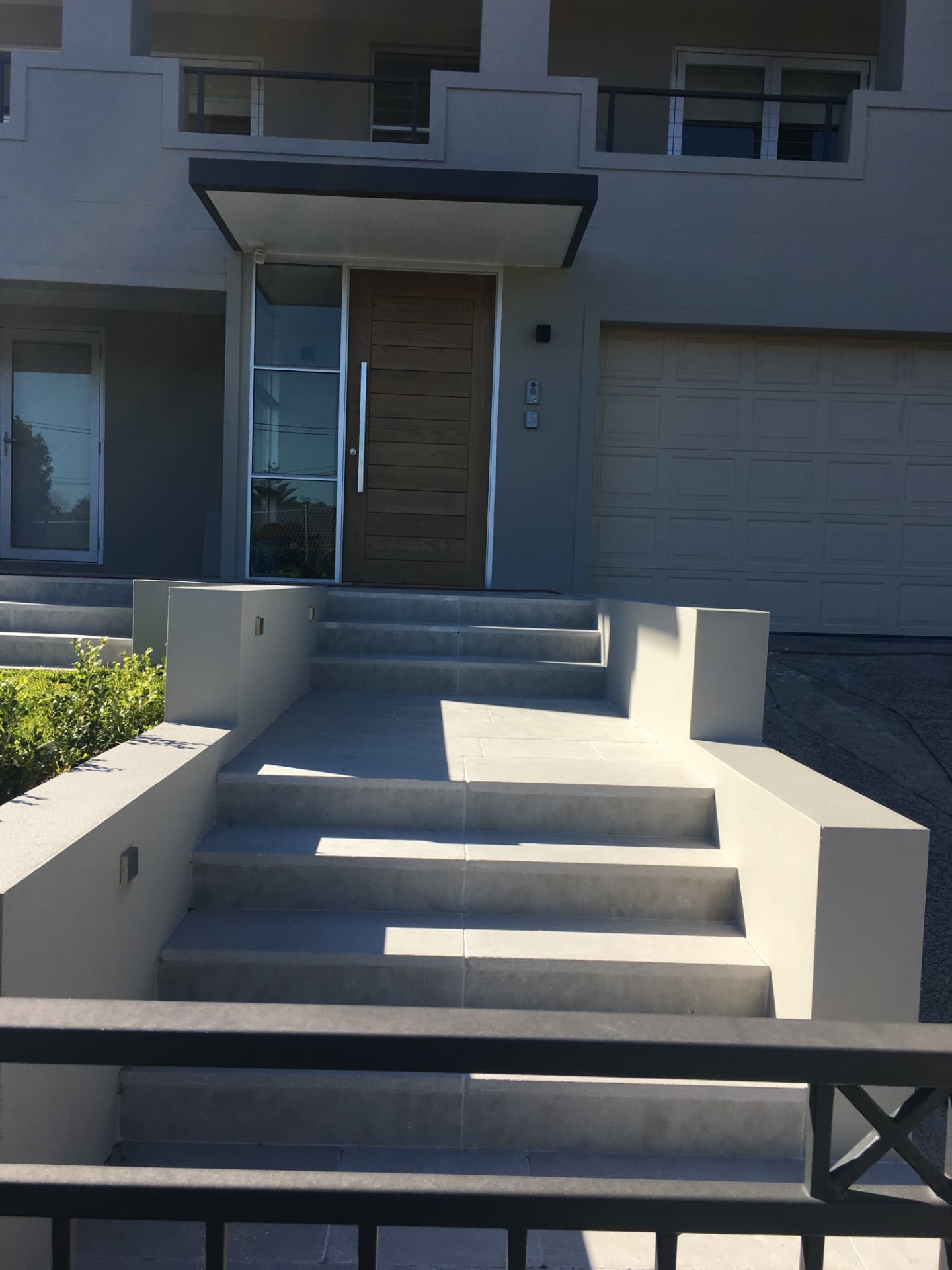 Riverview front entrance with tiled stairs, rendered walls and timber front door