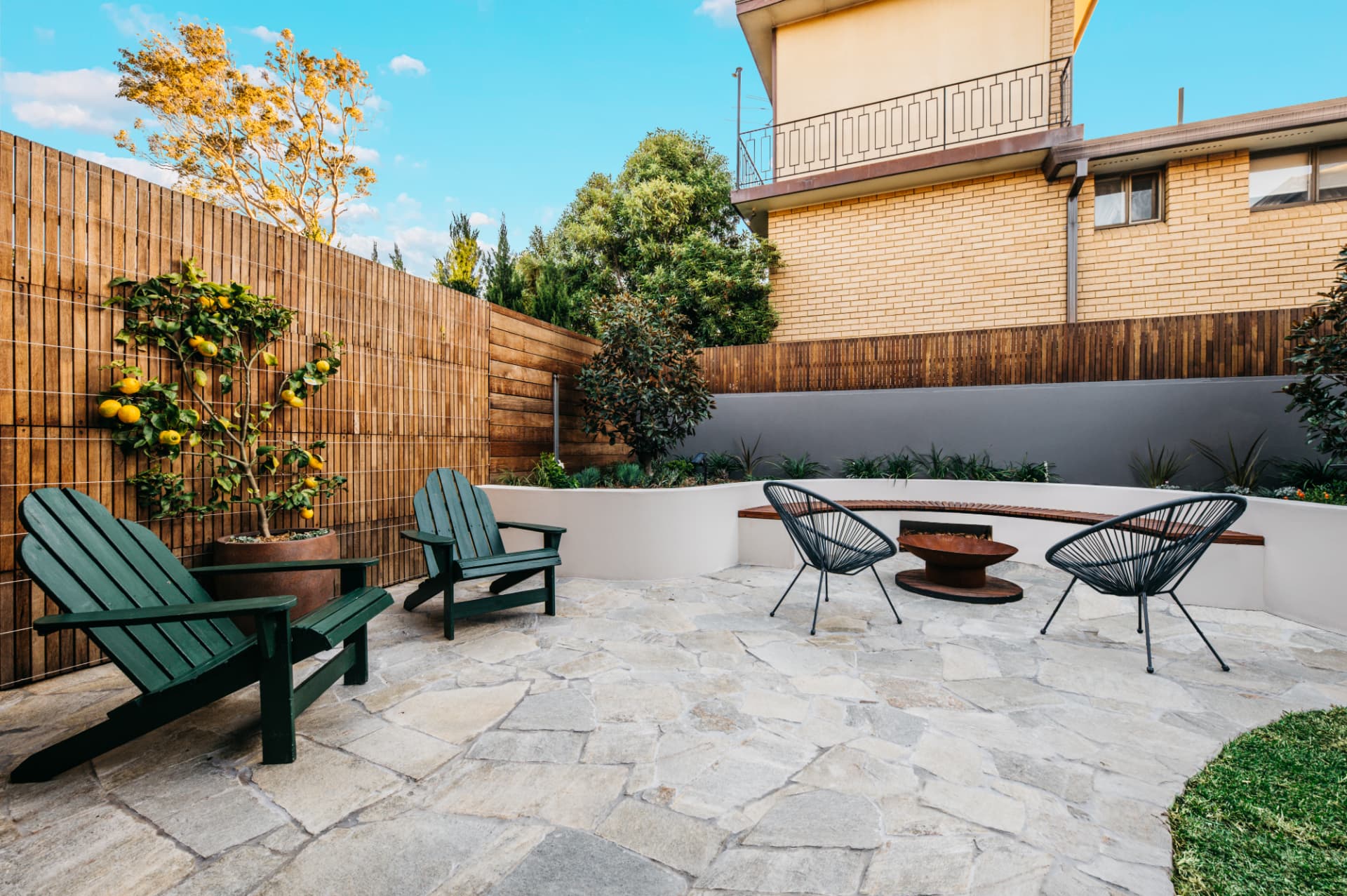 New crazy stone paving and rendered masonry walls with Adirondack chairs in the Wareemba courtyard