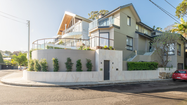 Frontage after the landscape design, with rendered walls, paving and established planting