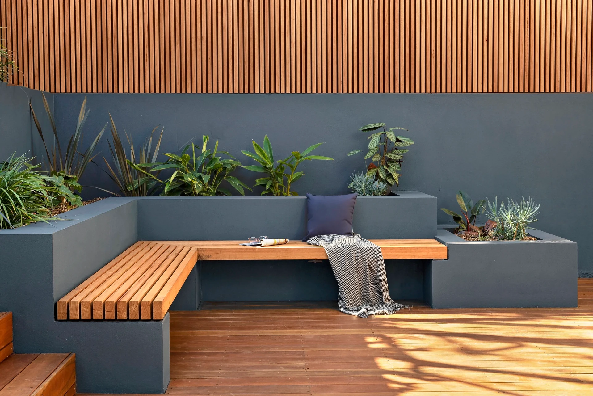 Built-in hardwood bench seating with rendered planter boxes and vertical timber screening in Greenwich