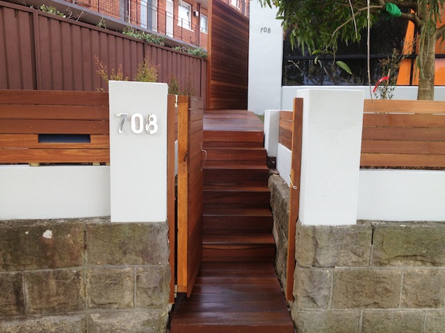 Finished front-entry timber steps between sandstone boundary walls at Kingsford