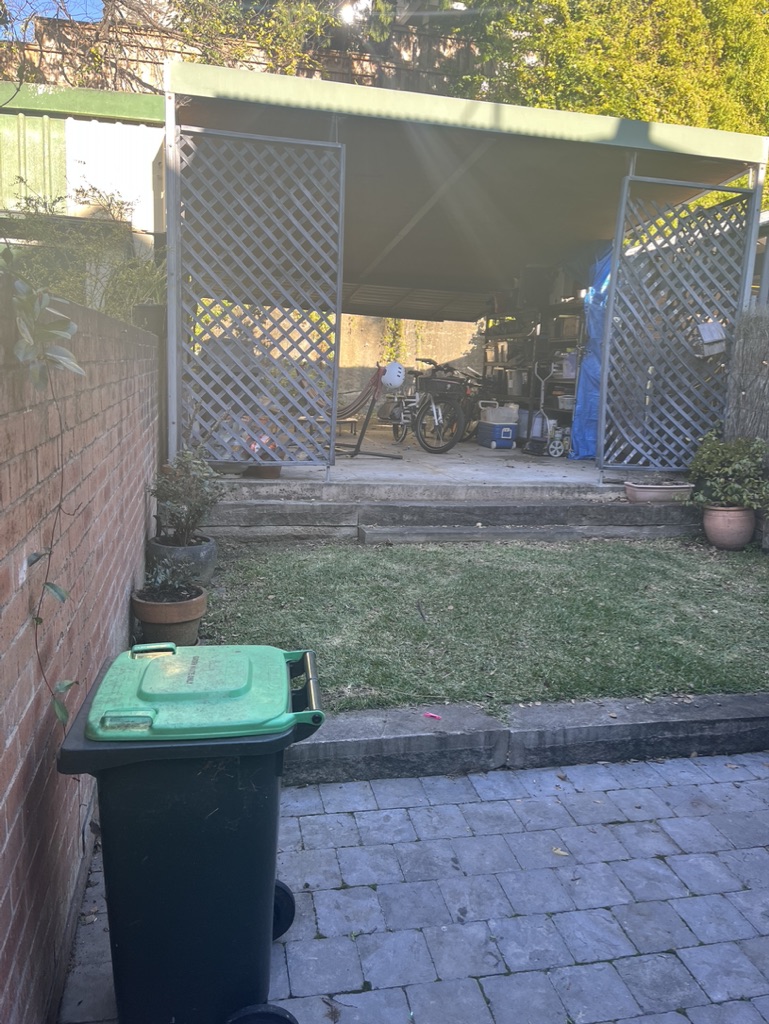 Before - Glebe backyard with the original lattice carport, bins and lawn before the rustic makeover
