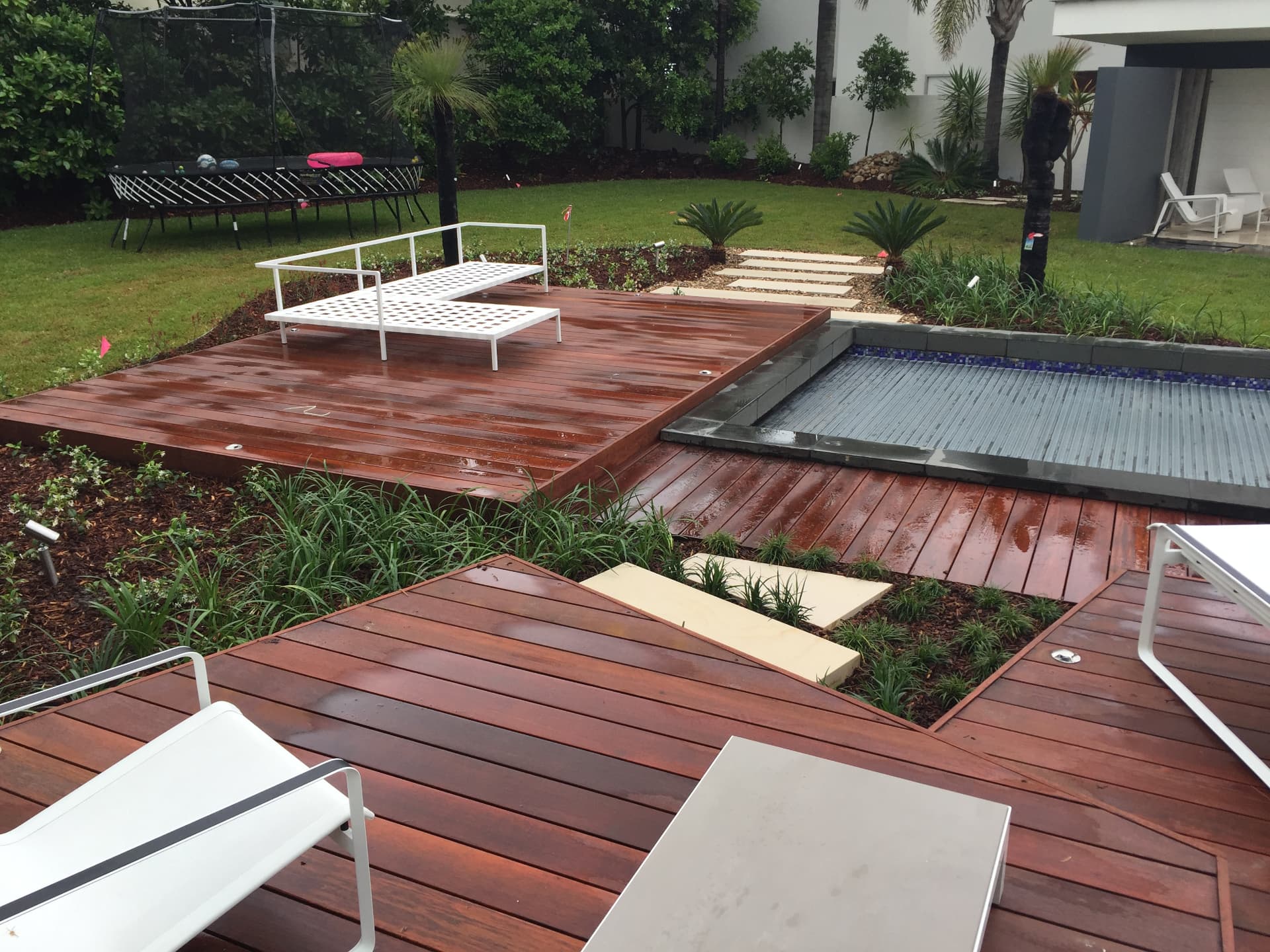 Timber decking with white loungers beside the pool at Dover Heights