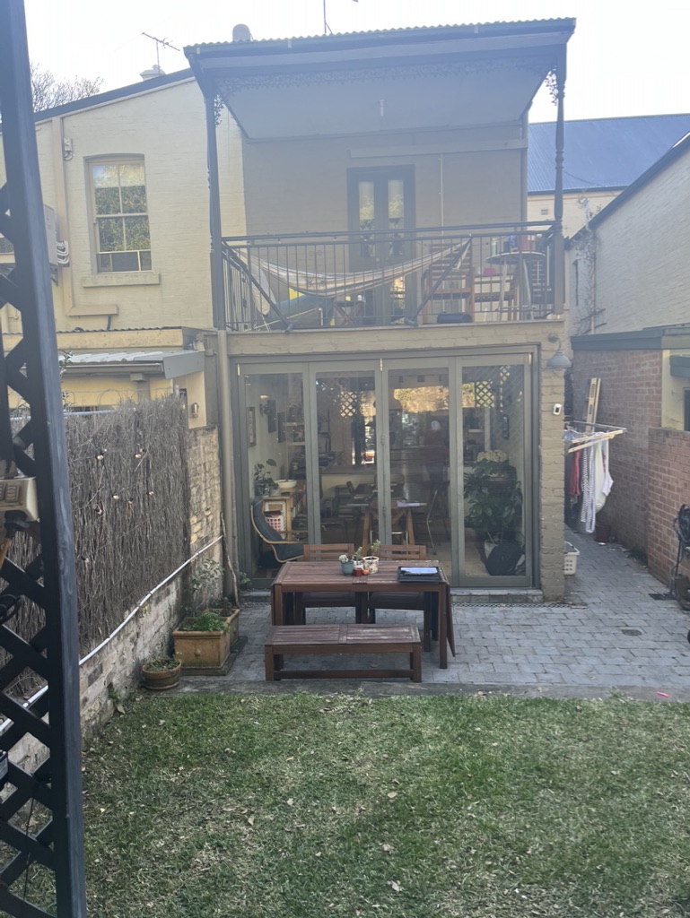 Before - rear of the Glebe terrace with the original pergola, paving and lawn before the makeover