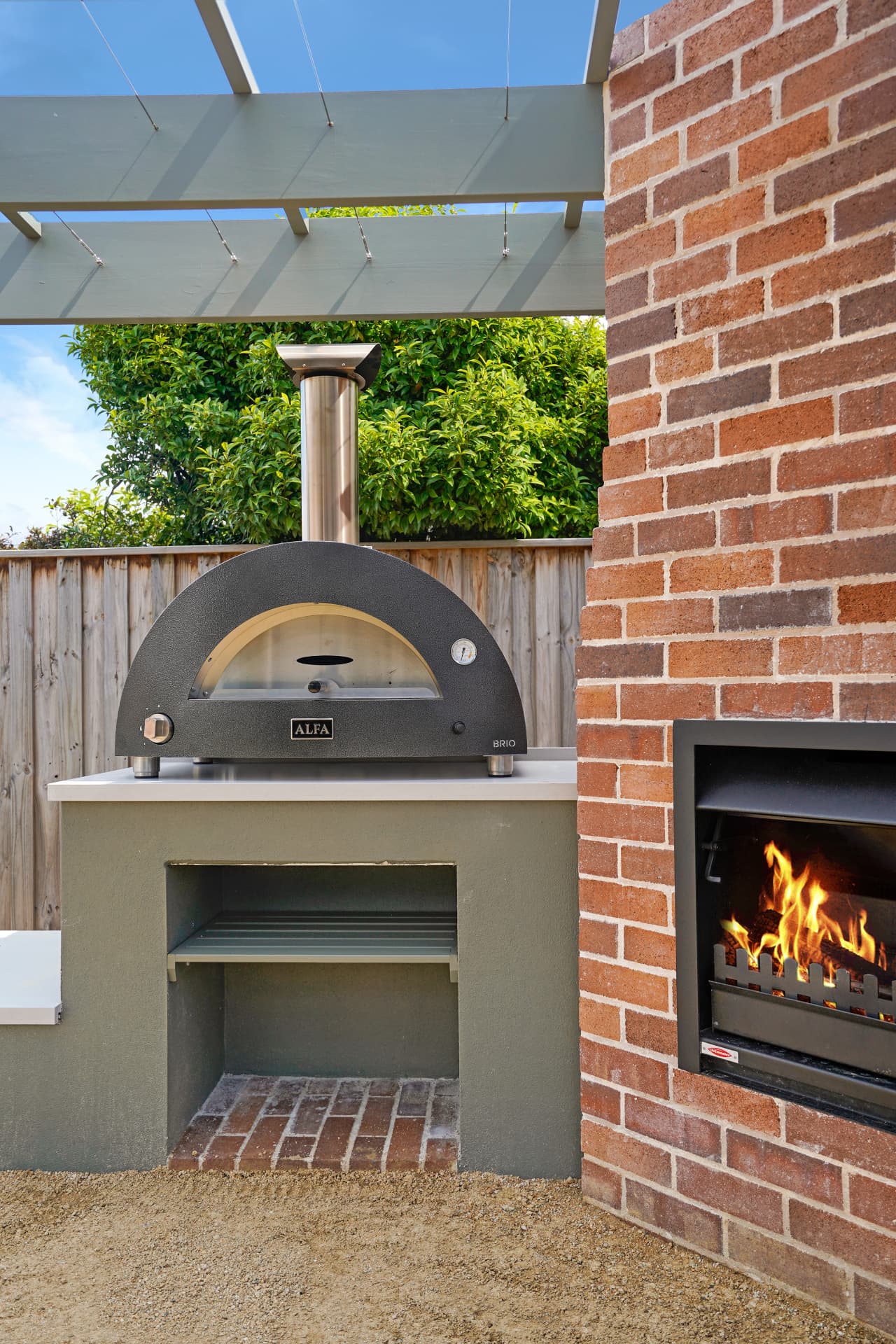 Alfa pizza oven on Caesar stone bench tops beside the brick fireplace in the Haberfield outdoor kitchen