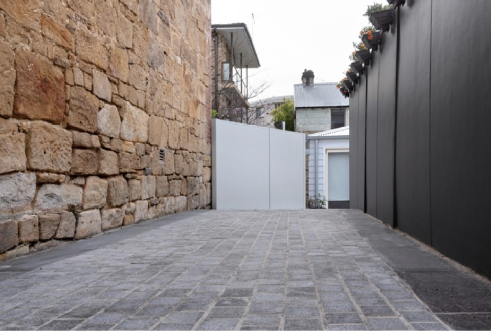 Cobblestone driveway alongside the heritage sandstone wall