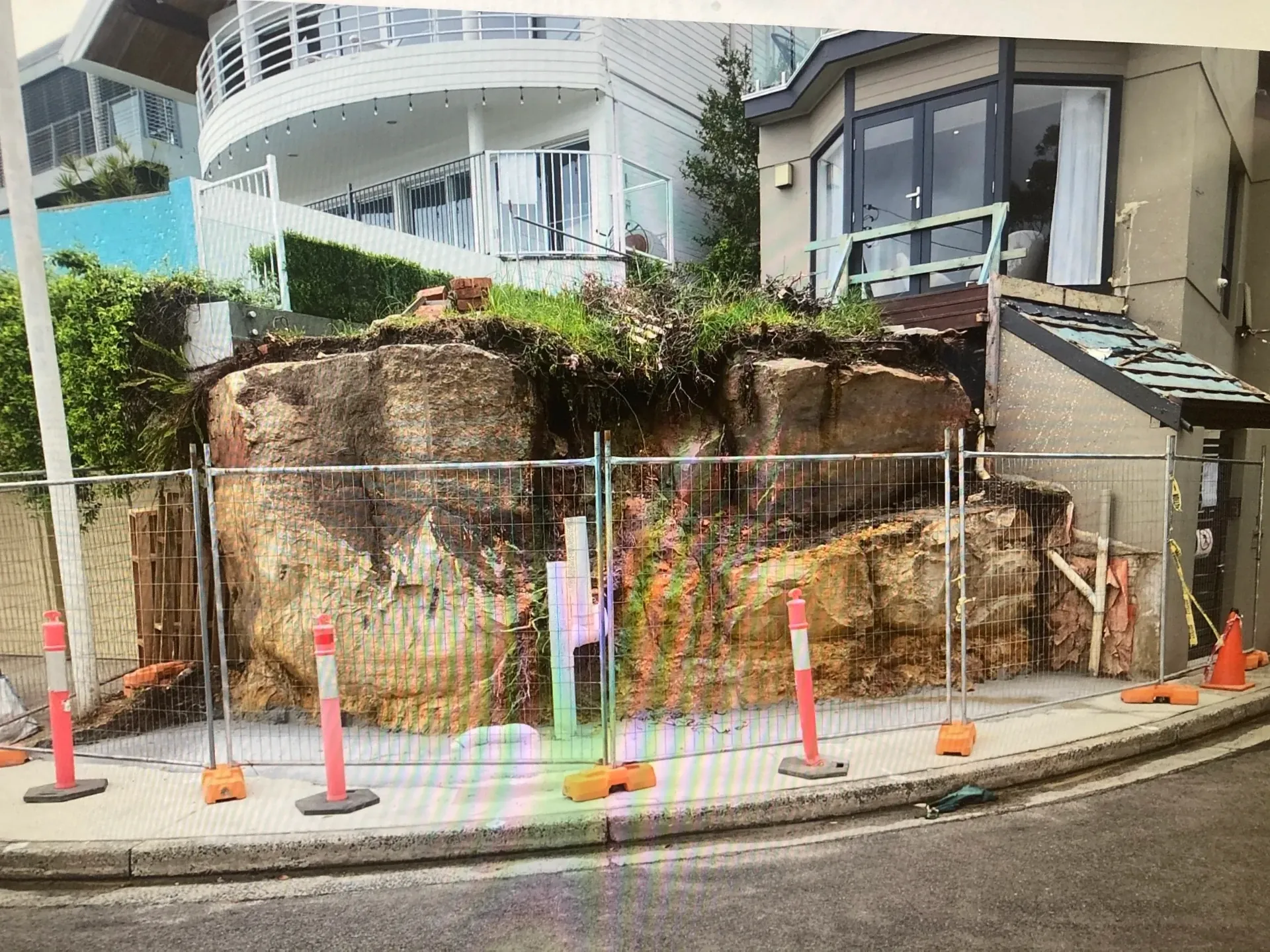 Before - exposed sandstone embankment fenced off after the original retaining failed