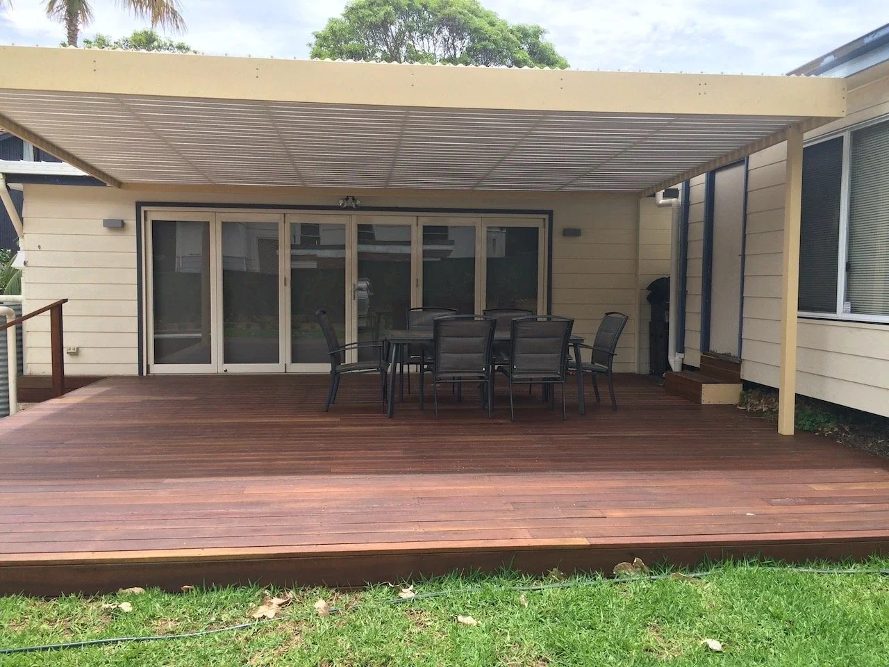 Chatswood hardwood deck under a louvred roof with dining setting off the bifold doors