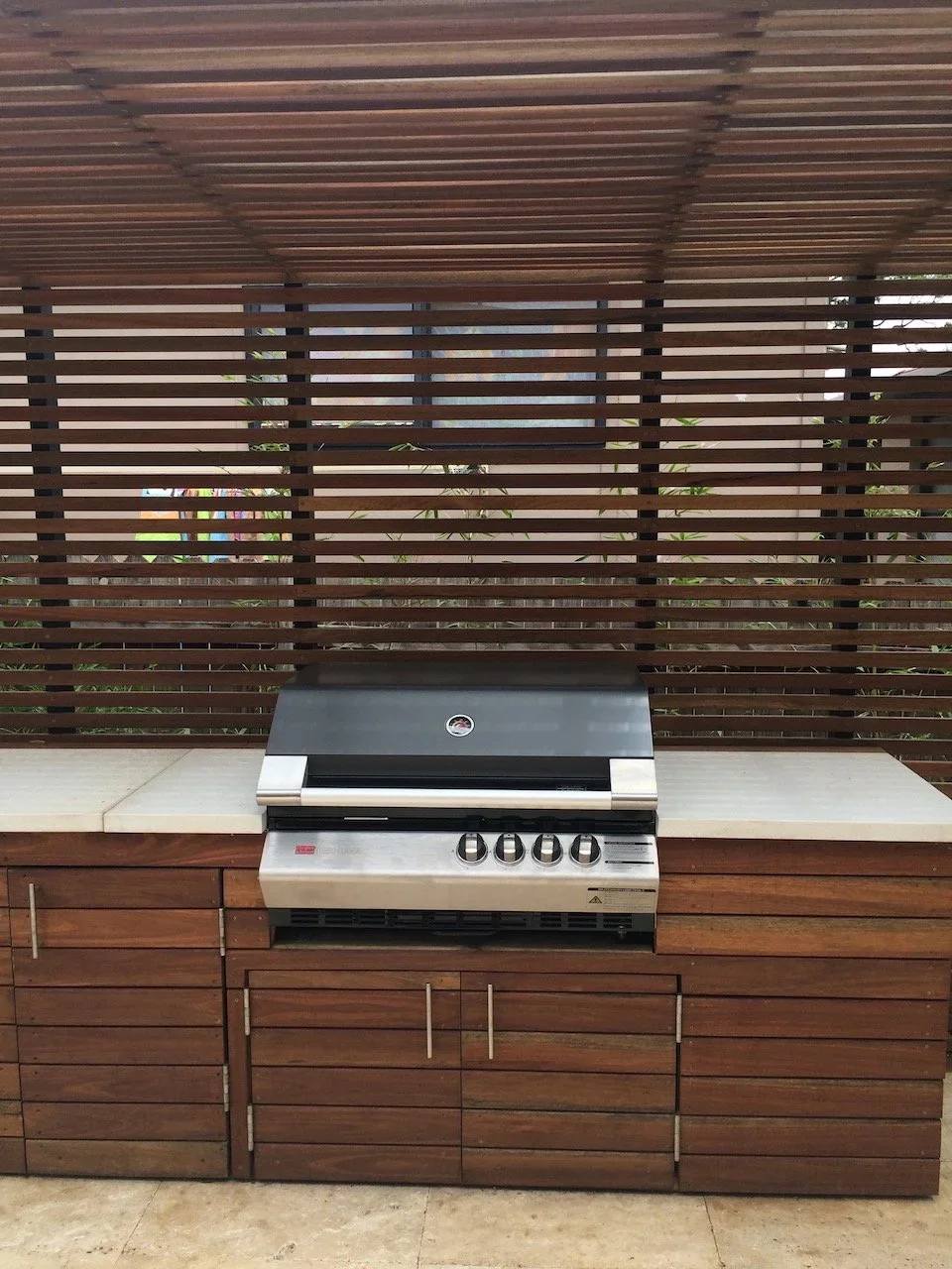 Detail of the spotted gum outdoor kitchen joinery, stone benchtop and slat privacy screen