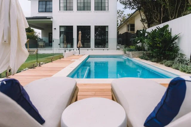 Chatswood pool with limestone coping and hardwood deck looking back to the white rendered home