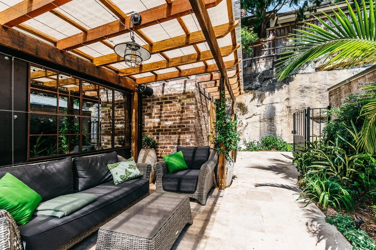 Honed travertine terrace running past the lounge setting to the sandstone rock face