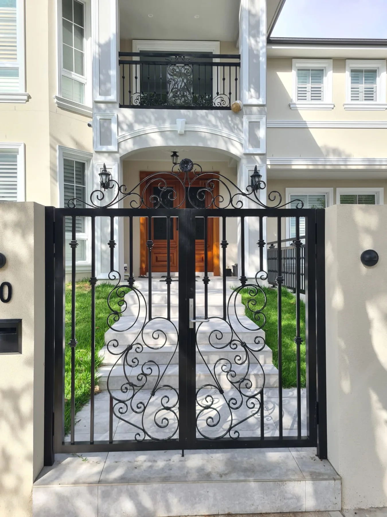 Entry gate framing stairs and the front door of the Killara home