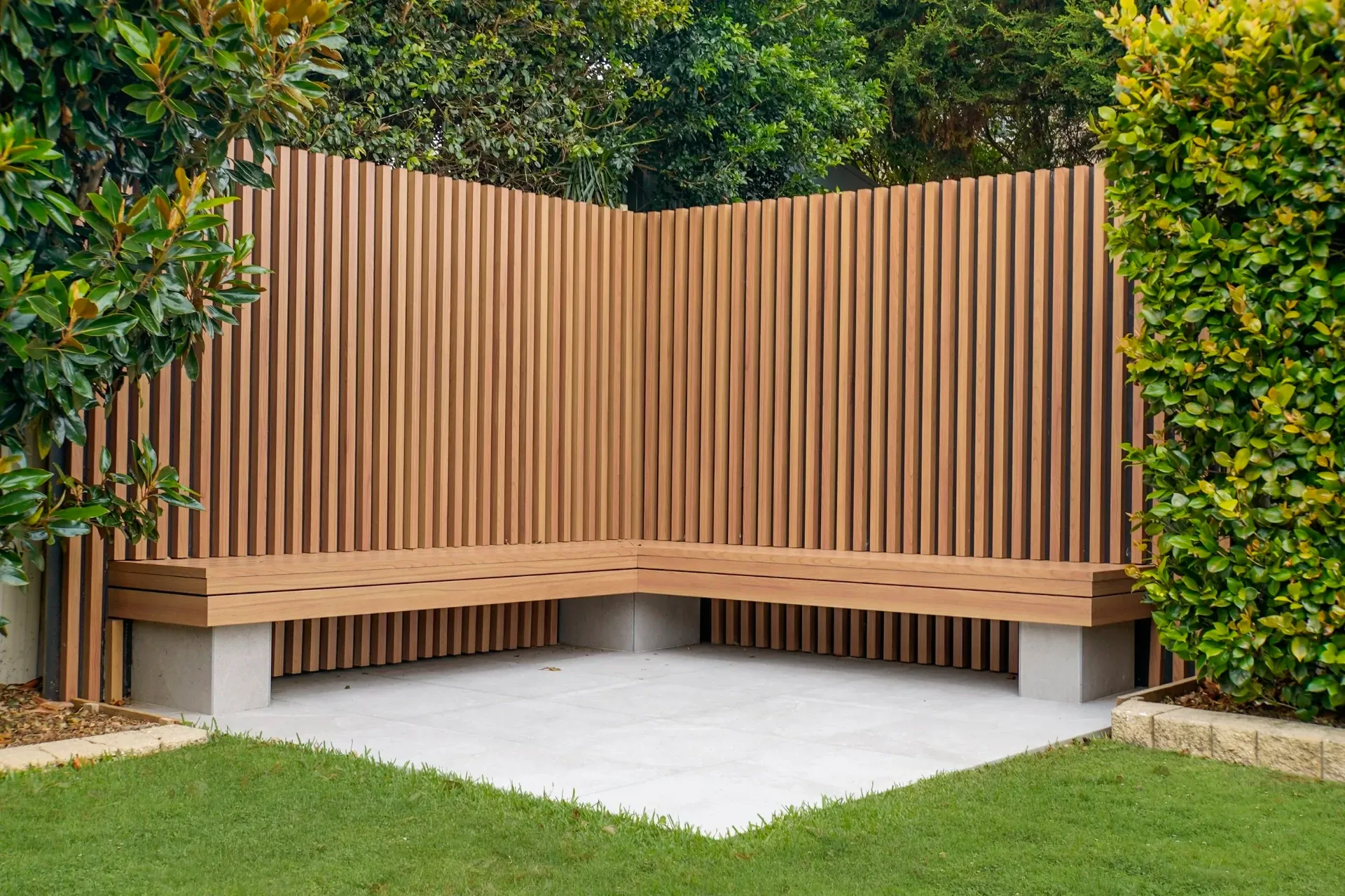 Corner bench seat with battened screen backing and paved landing at the rear of the garden
