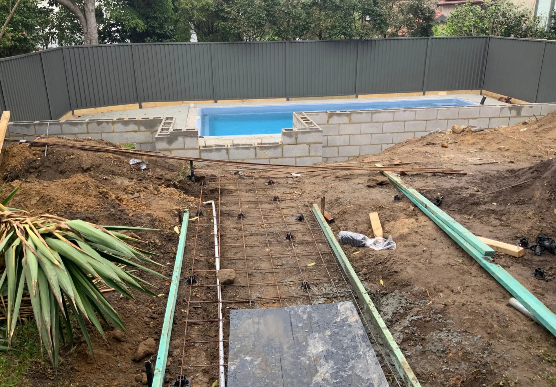 Before - the Riverview pool shell set in place with blockwork retaining under construction