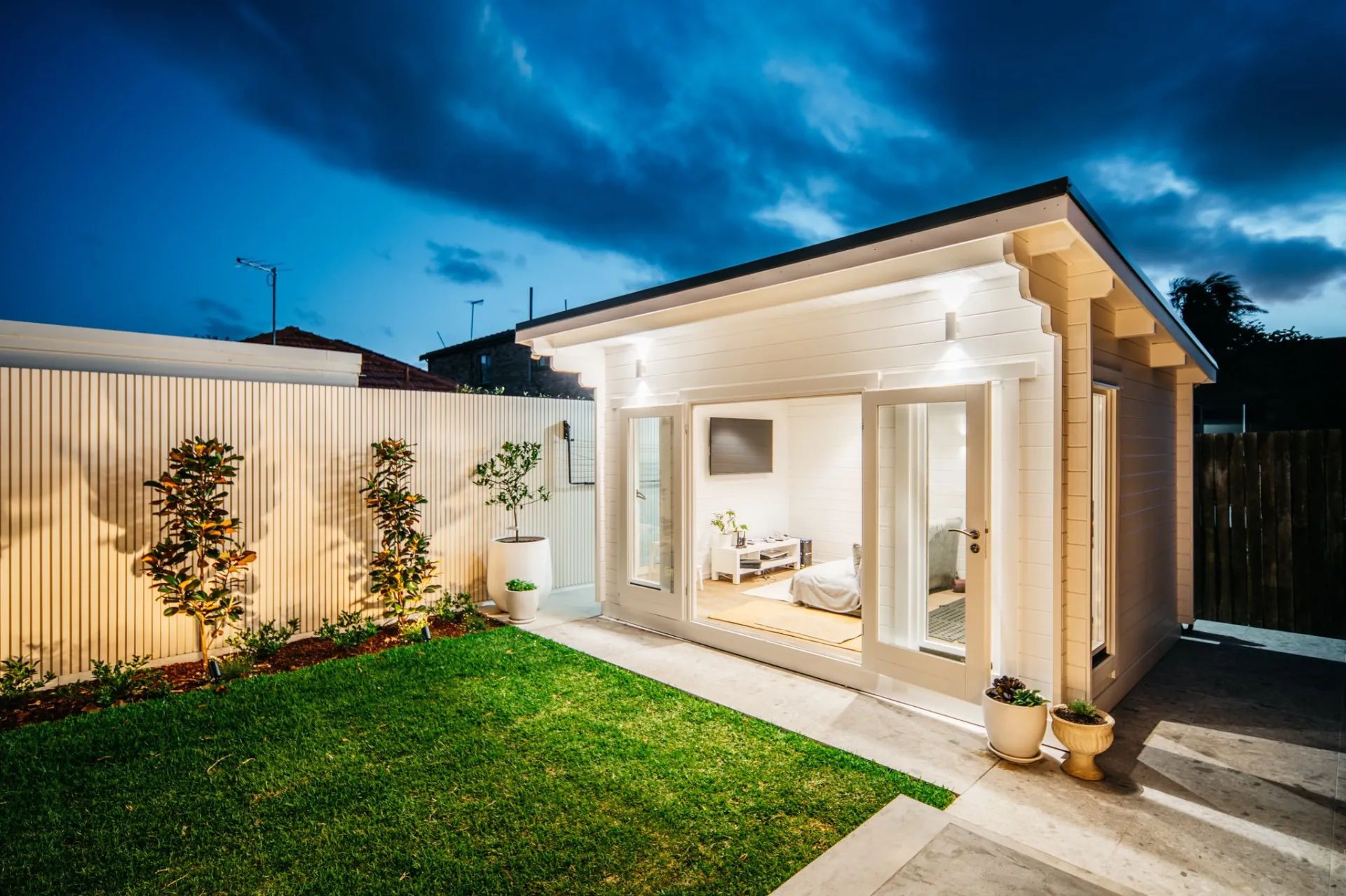 Lit outdoor cabana against a dusk sky in an Inner West courtyard