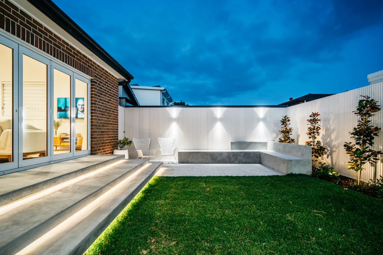 Concrete bench seating with LED-lit step risers and uplit batten screen
