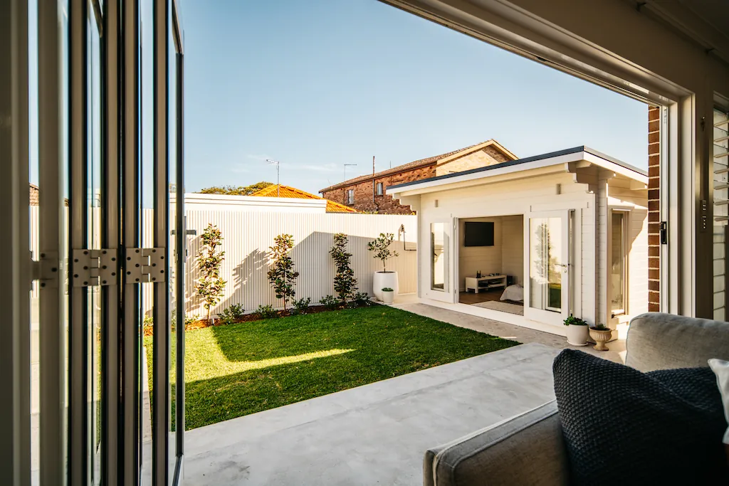 View from the living room through bifold doors to the lawn, terrace and cabana