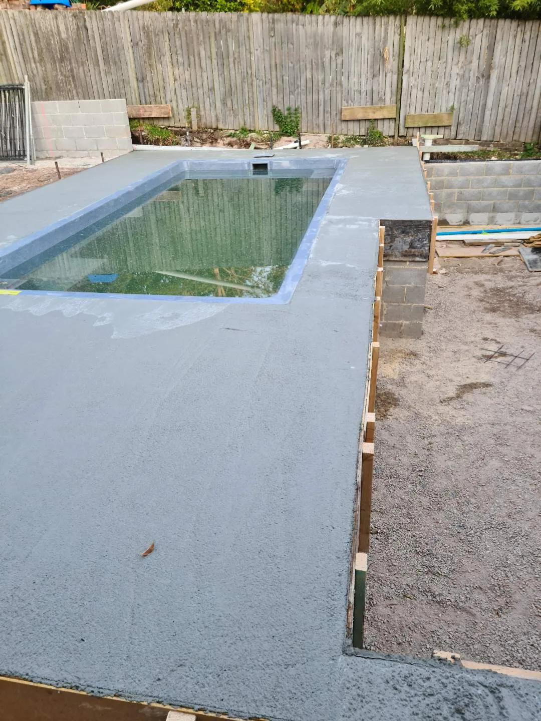 During construction - freshly poured concrete surround around the newly set pool shell