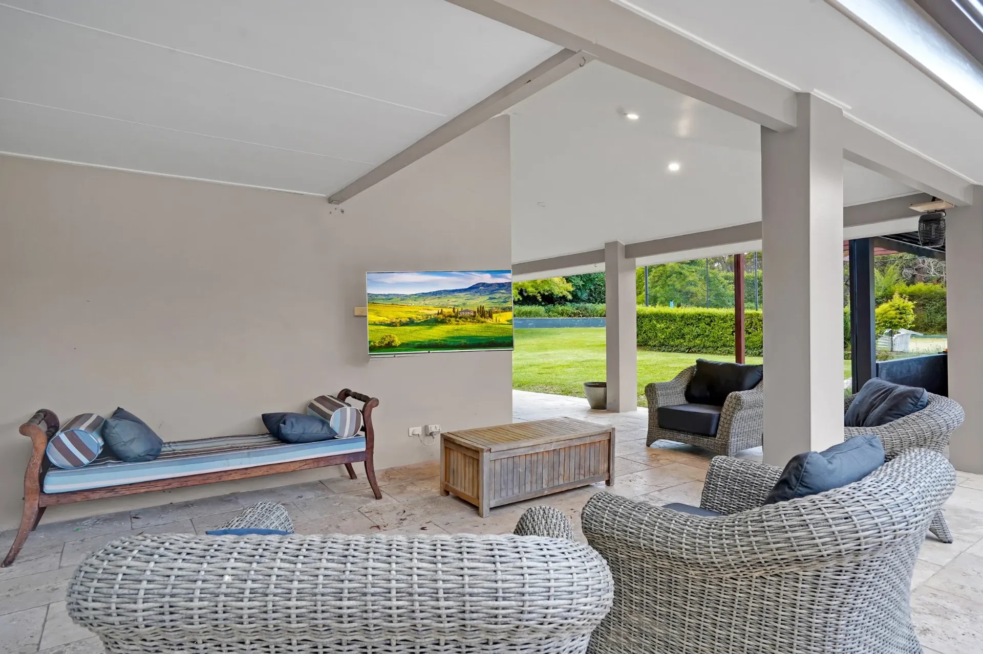 Covered patio lounge opening to the level lawn and pool area